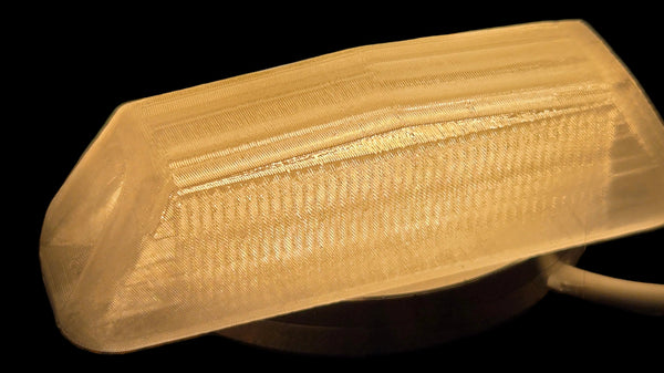 Close-up of a light bulb with a textured cover on a dark background
